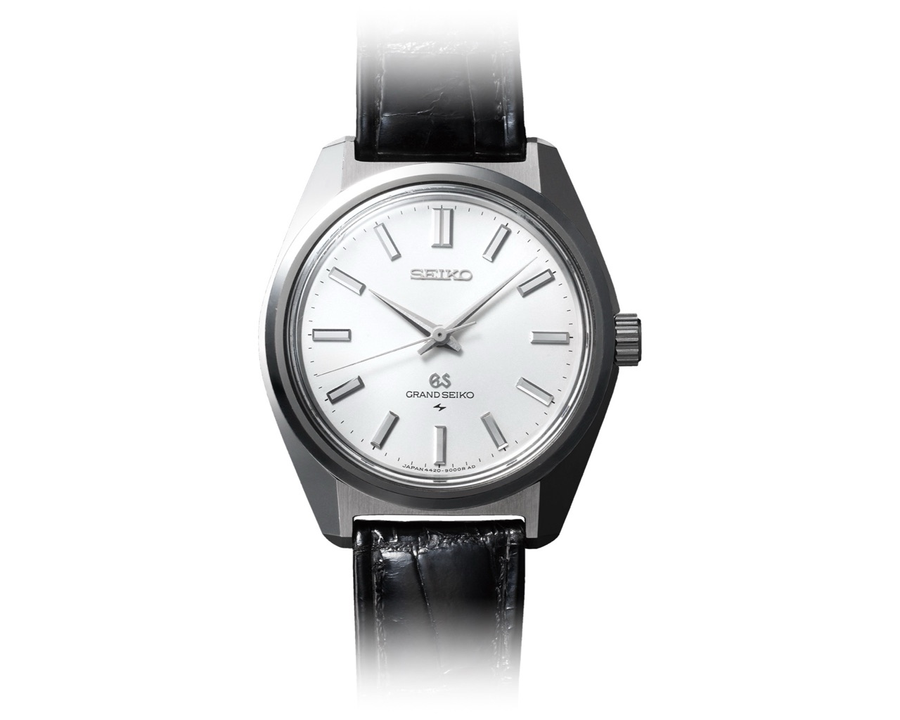 The 1967 Grand Seiko 44GS seen straight on, its wide mirror-polished bezel meeting a flat brushed case top along a single unbroken ridge, above a silvered dial with faceted baton indices